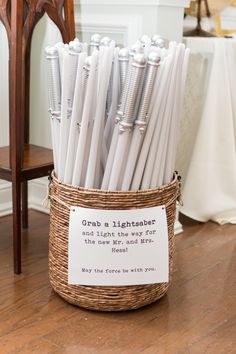 a basket filled with white candles on top of a wooden floor