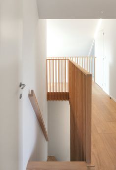 an empty staircase with wooden handrails and white walls