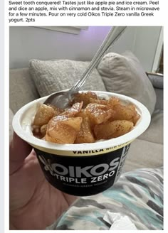 a person holding up a bowl of food with a spoon in it's hand