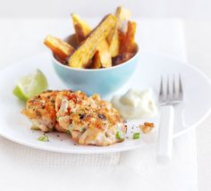 a white plate topped with food next to a bowl of fries