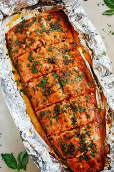 baked salmon fillet in foil with herbs on top