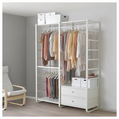 a white closet with clothes hanging on the rails and drawers in front of it, next to a bed