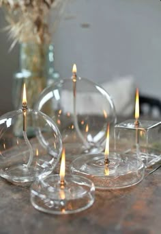 four clear candles sitting on top of a table