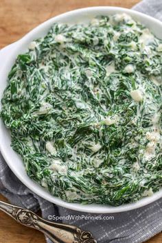 a white bowl filled with spinach and cheese