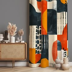 an abstract shower curtain with orange and blue shapes on it in a living room setting