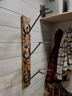 the coat rack is made out of wood and has two hooks on it, along with several coats