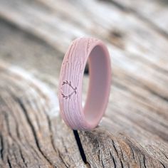 a pink ring sitting on top of a wooden table