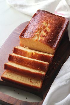 a sliced loaf of pound cake sitting on top of a wooden cutting board