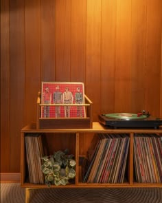 an old record player sits on top of a wooden shelf next to some vinyl records