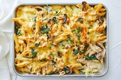 a casserole dish with pasta, mushrooms and spinach