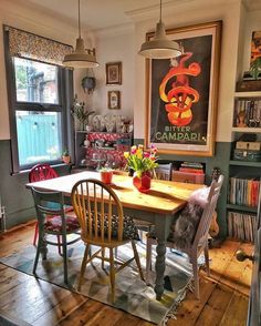 a dining room table with two chairs next to a window