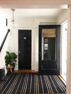 a black door and some plants in a room