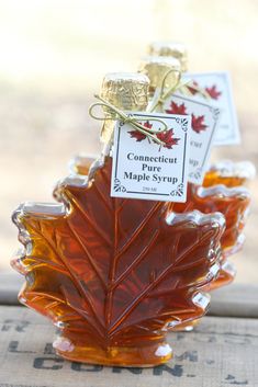 the maple syrup is being poured into small glass jars with tags attached to each bottle