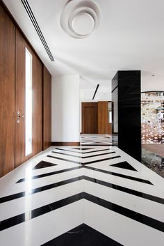 an empty room with black and white flooring in the center is seen from across the room