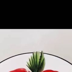 two red peppers sitting on top of a white plate