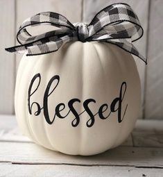 a white pumpkin with a black and white ribbon tied around it's head that says, blessed