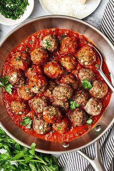 meatballs in marinara sauce with parsley on the side