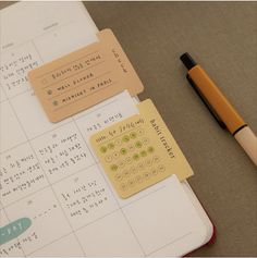 an open notebook with stickers on it and a pen sitting next to the pages