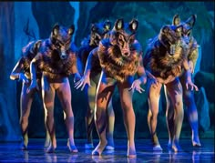 the wolf dancers are performing on stage in costumes with furs and furry collars