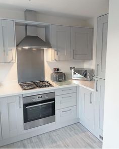 a kitchen with white cabinets and silver appliances