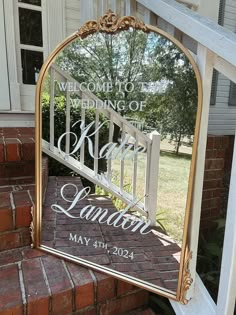 a mirror that is on the side of a brick building with a welcome sign in it