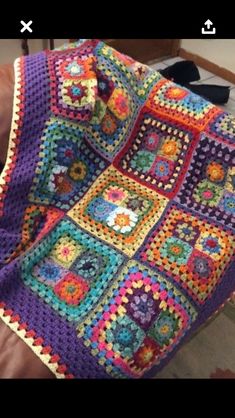 a crocheted granny blanket sitting on top of a couch