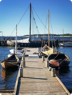 several small boats docked at a pier in the water