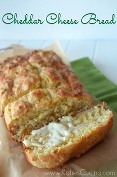 a loaf of cheddar cheese bread sitting on top of a piece of wax paper