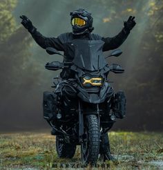 a man riding on the back of a motorcycle wearing a black jacket and yellow goggles