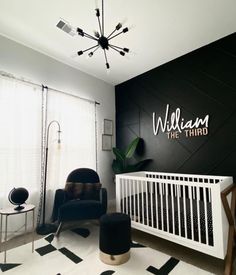 a baby's room with black and white walls, a crib, and a rocking chair