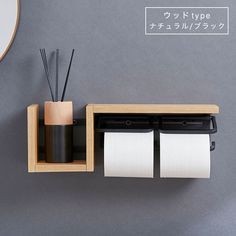 a wooden shelf with two rolls of paper on it and some sort of toothbrush holder