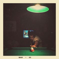 a man is playing pool in the dark