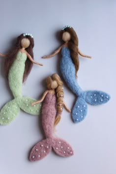 three little mermaid dolls sitting next to each other