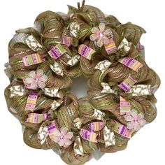 a brown wreath with pink flowers and ribbons on it's side, sitting in front of a white background