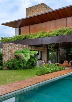 a house with a pool in front of it and some plants growing on the roof