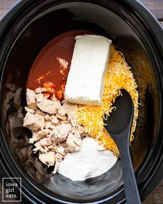 the ingredients for an enchilada in a slow cooker