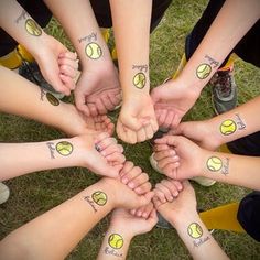 a group of people holding hands with tattoos on their arms and feet in the shape of a circle