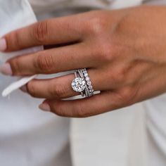 a close up of a person's hand with two rings on their fingers and one ring in the middle