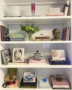 the shelves are filled with books, pictures and vases on top of each shelf