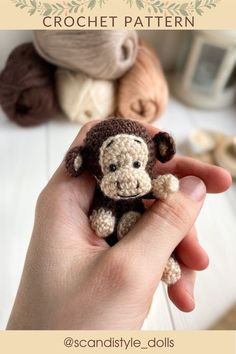 a hand holding a small crocheted monkey in it's right hand, next to other stuffed animals