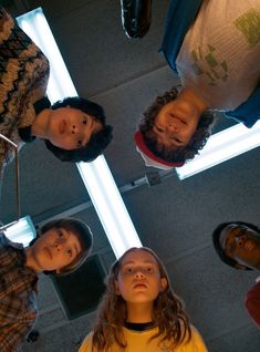 four people standing in a circle looking up