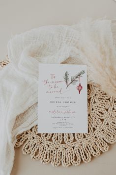 the wedding stationery is laid out on top of a doily with a white cloth