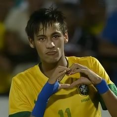 a soccer player with his hands in the shape of a heart on his left hand