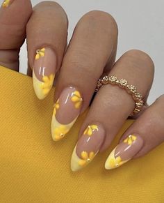 a woman's nails with yellow flowers on them