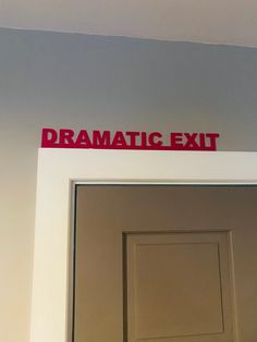 an exit door with the words dramatic exit painted on it's red sign above