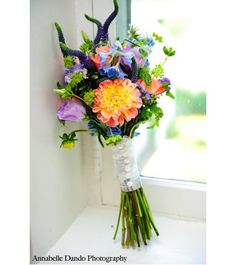 a bouquet of flowers sitting on top of a window sill