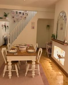 the dining table is set for four at the end of the stairs leading up to the second floor