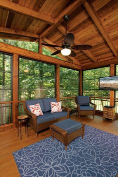 a living room filled with furniture and lots of windows on top of a wooden floor