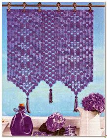 a purple crocheted curtain with tassels hanging from it