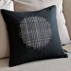 a black and white pillow sitting on top of a couch